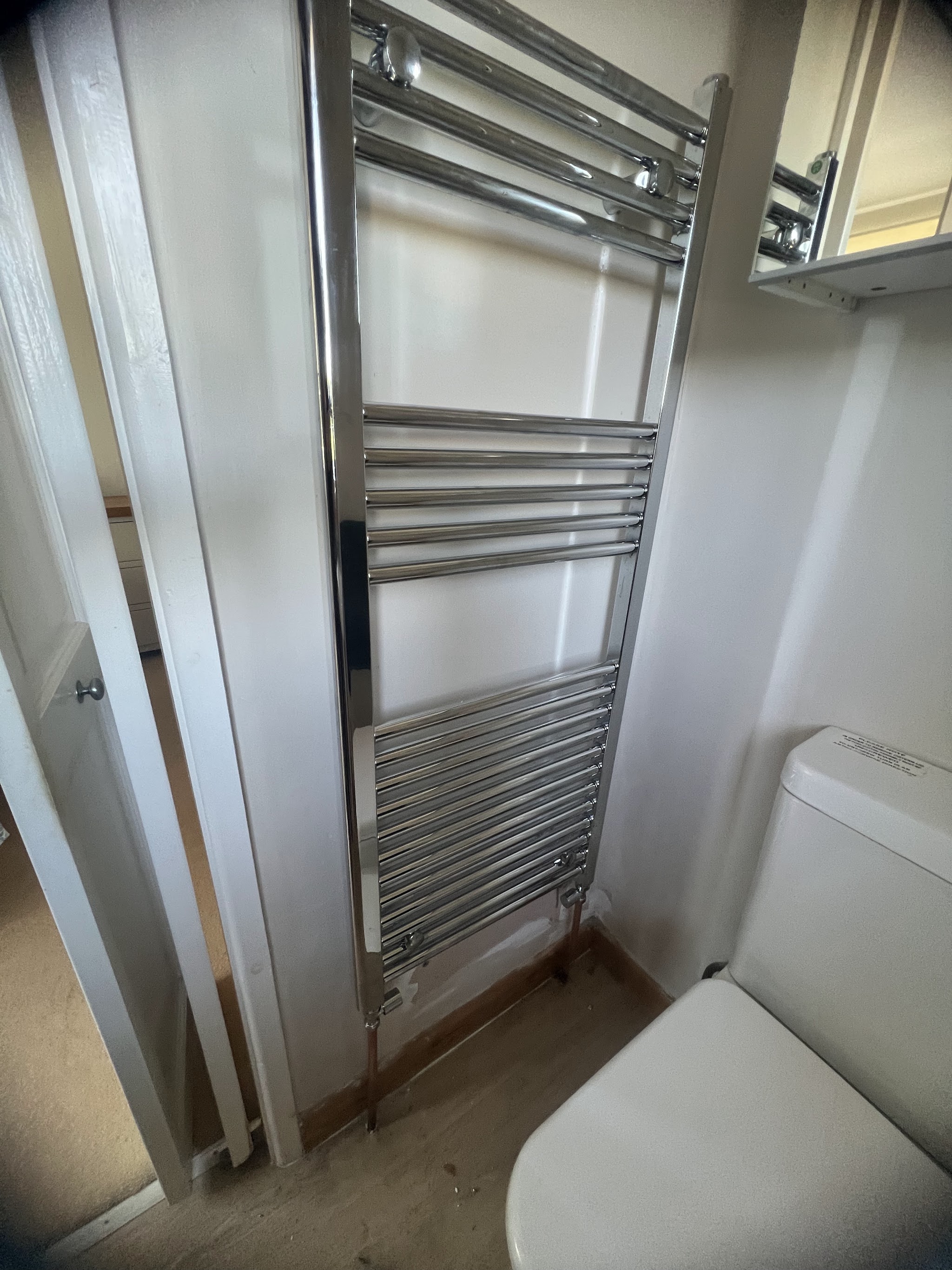 Chrome towel rail fitted beside a toilet