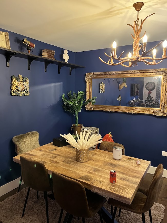 Dining room with wall shelf, large gilt mirror and chandelier