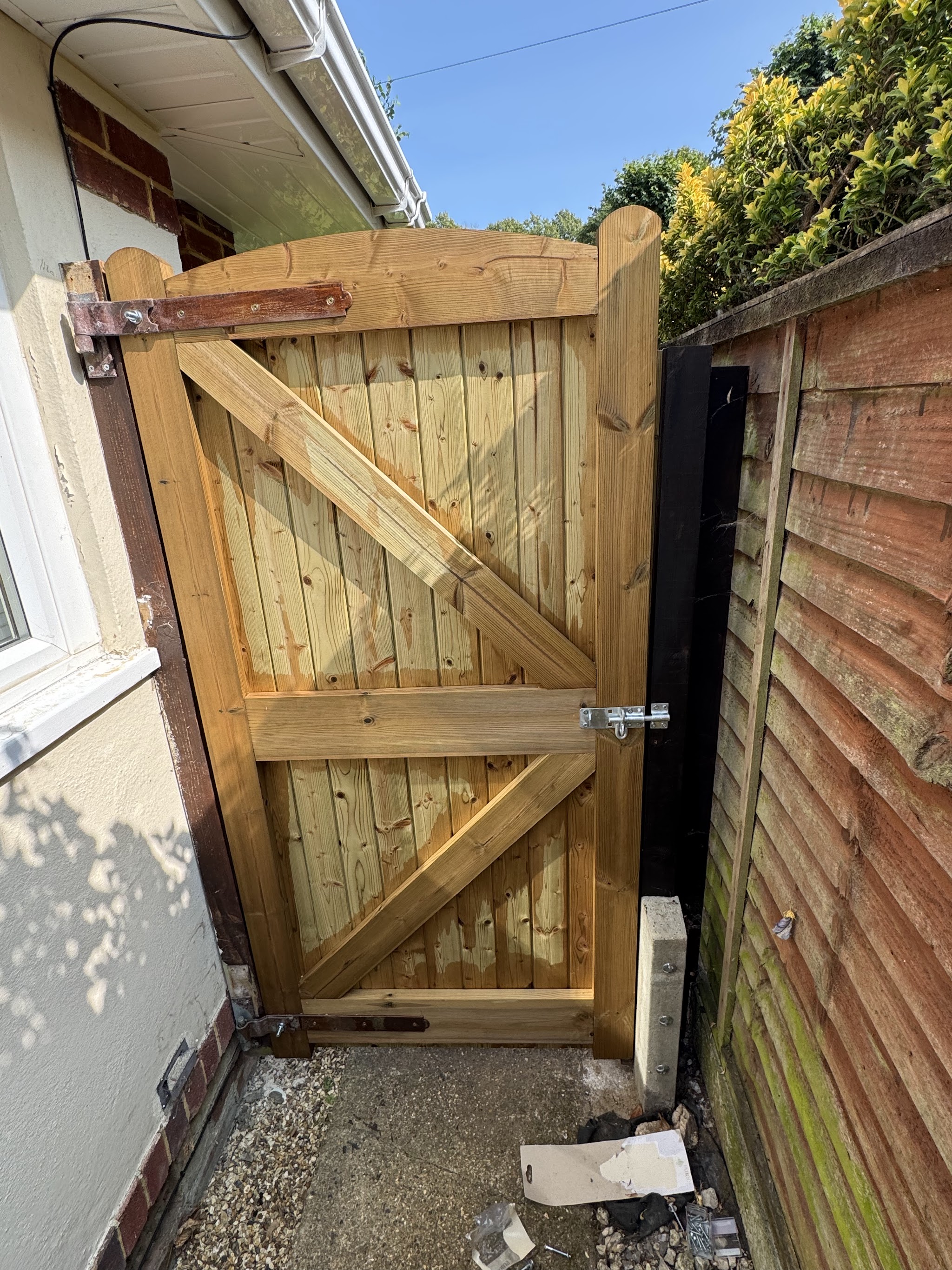 New timber side gate fitted between a house and fence