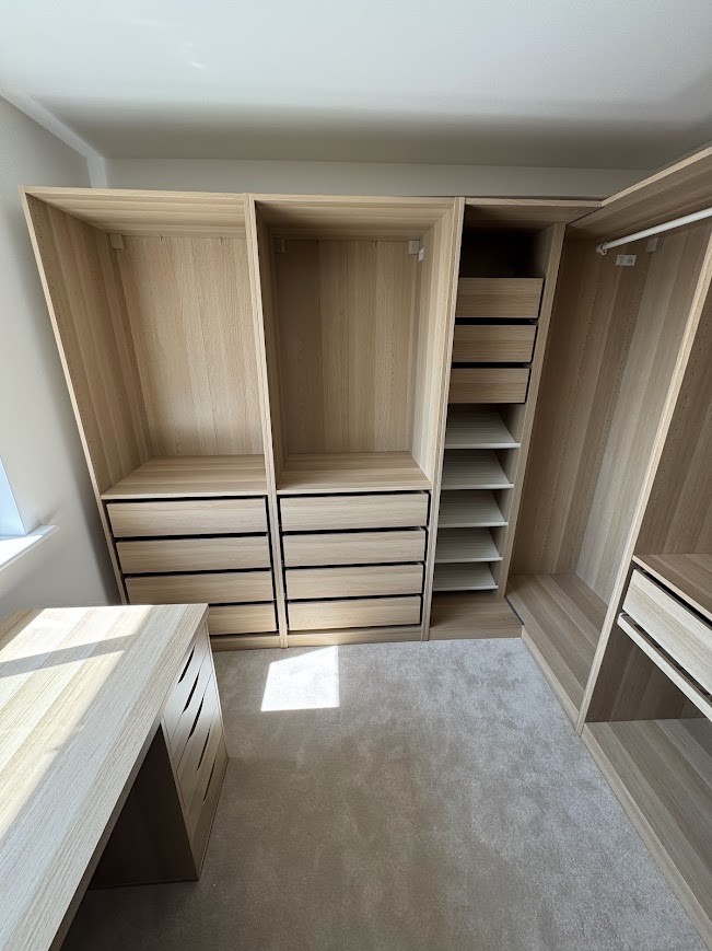 Fitted wardrobe and drawer unit assembled in a bedroom